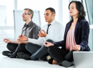 Successful businesspeople meditating in the office.